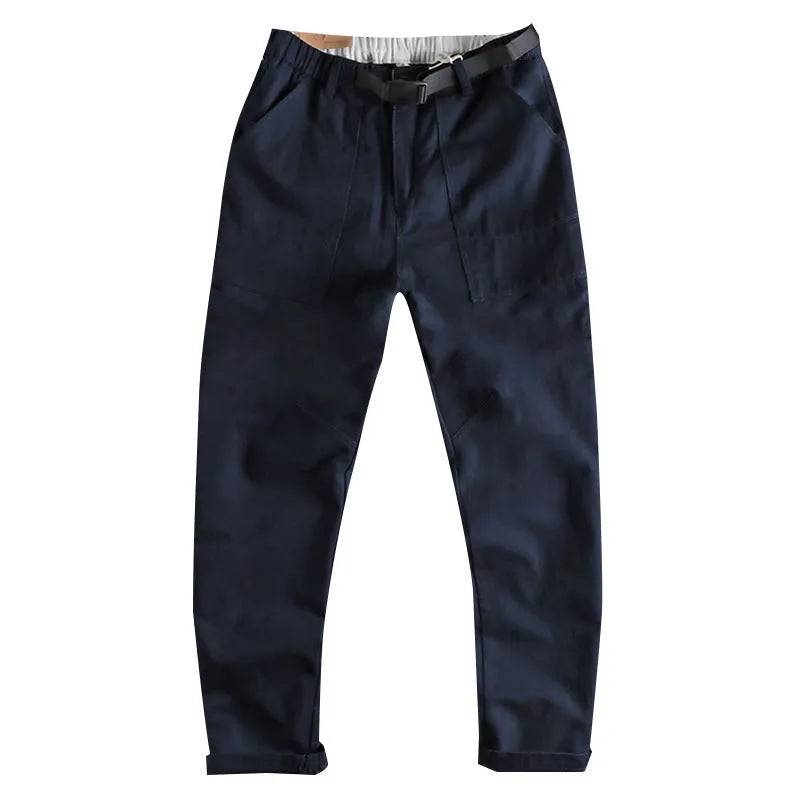 Men's khaki cotton work trousers with N buckle belt on a mid waist, showing three-dimensional cut.