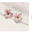 Women's flower stud earrings with electroplated pink or white finish on alloy construction