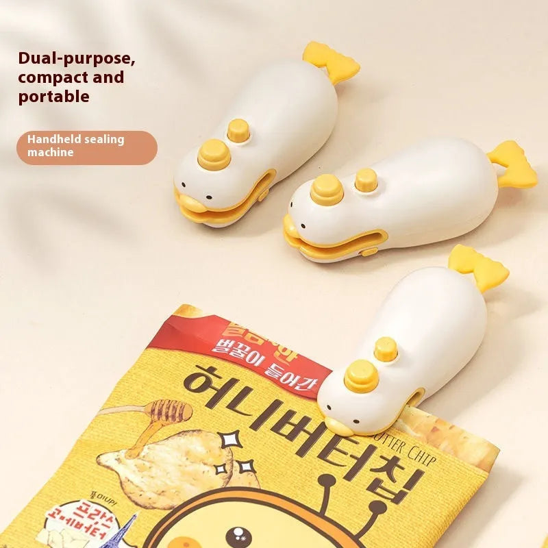 Small yellow duck shaped rechargeable sealing machine with charging cable on a white background.