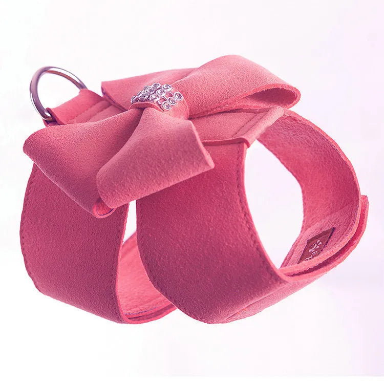 Puppy wearing a blue microfiber chest strap with a decorative bowknot, showing the adjustable lead attachment.