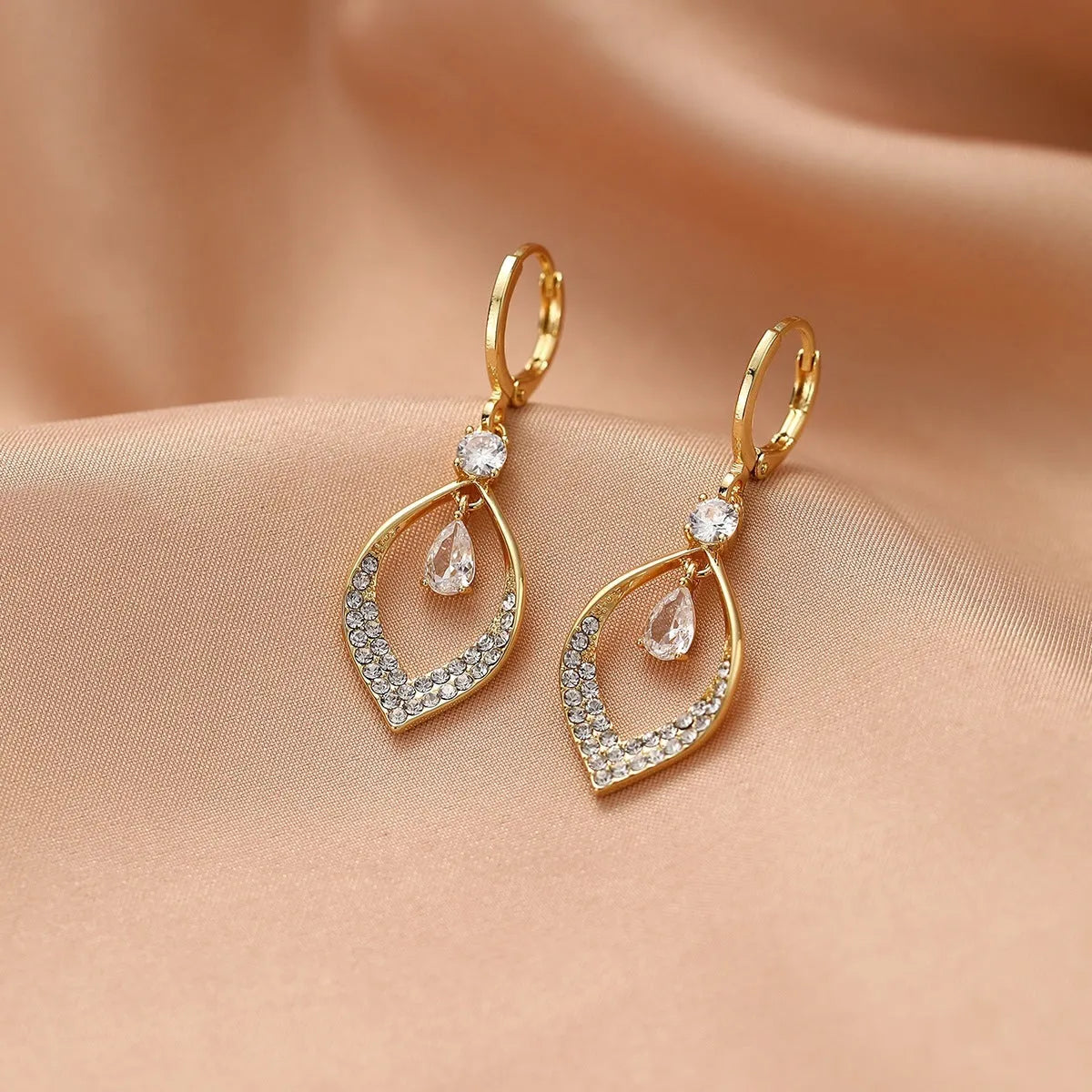 Copper electroplated women's earrings with a teardrop shape, water drop tassels, and zircon stones in gold colour.