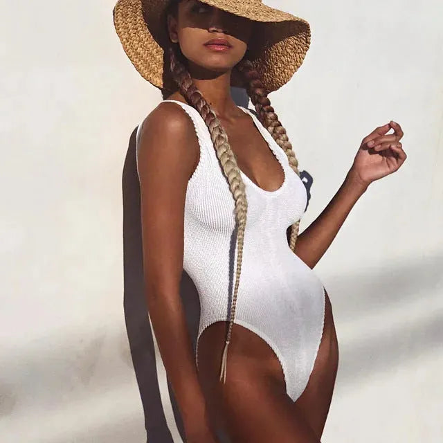 A solid colour, sleeveless, backless one-piece swimsuit for women, shown in seersucker fabric.