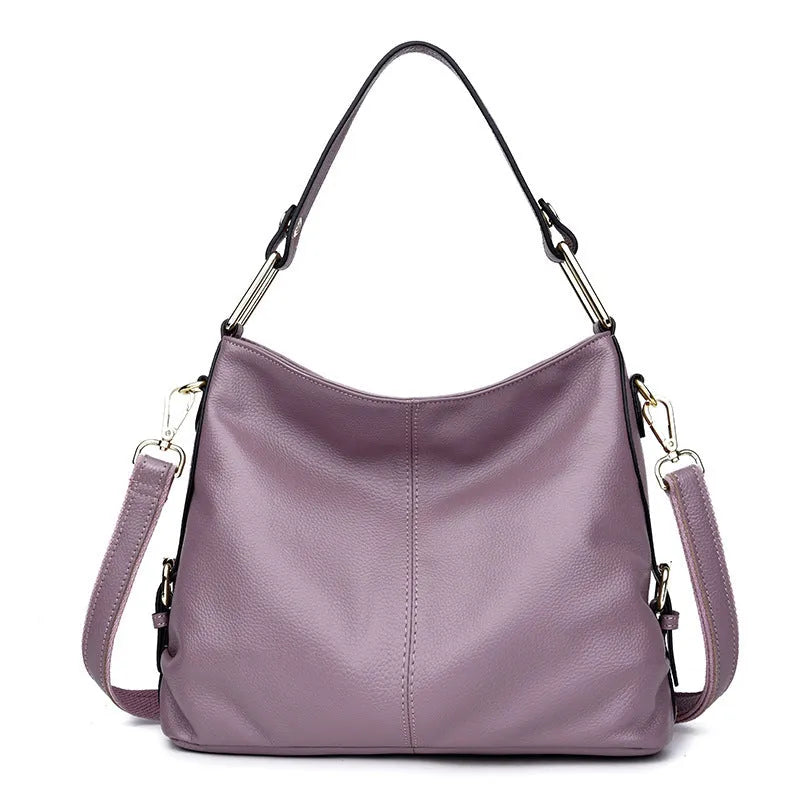 Genuine leather vertical square crossbody bag in black showing outer pocket and structured shape.