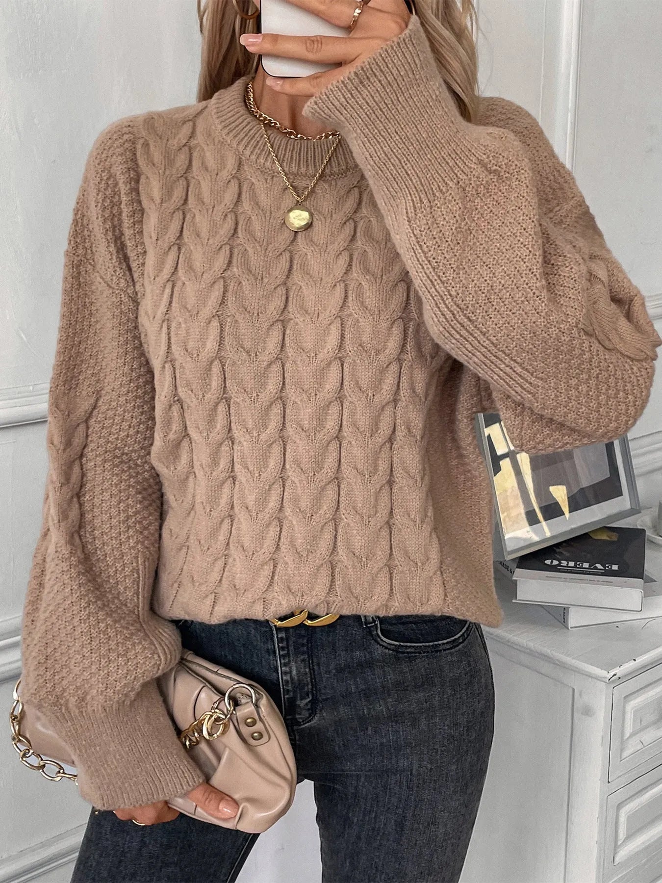 Women's beige loose round neck casual polyester sweater on a hanger.