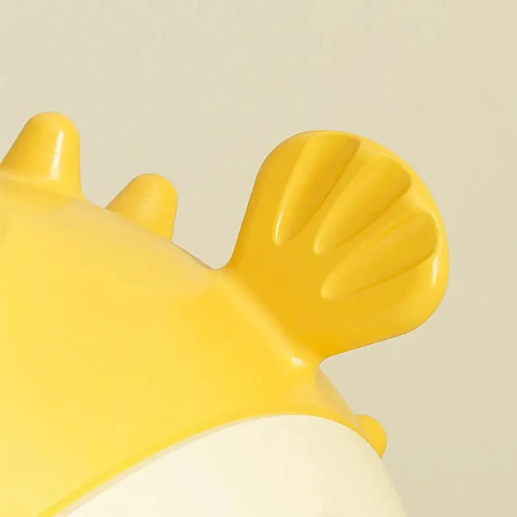 Yellow vinyl fish-shaped dog chew toy with textured surface and squeaker.