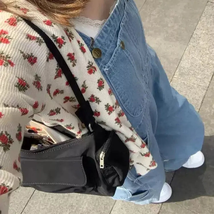 Black women's shoulder bag with two front pockets showing side line stitching detail