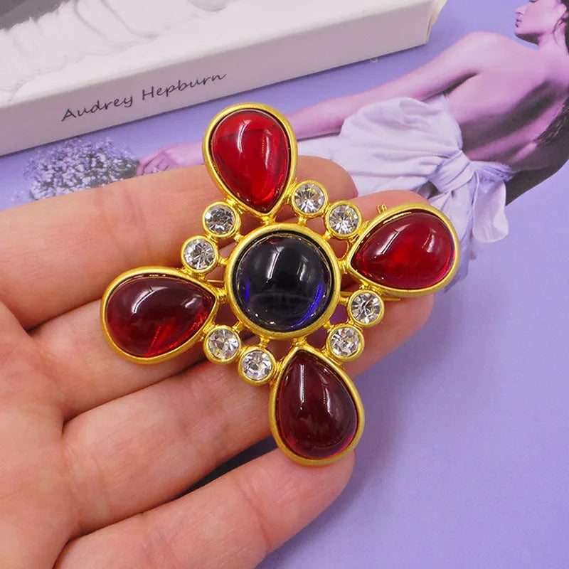 A vintage-style zinc alloy brooch with a baroque cross design and crystal accents.