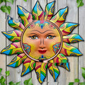 Iron sun face metal wall hanging decoration on a plain background