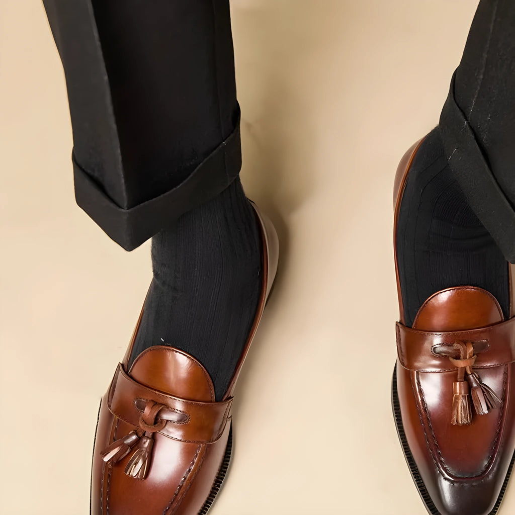 Men's black and brown tassel loafers with polished leather uppers and rubber soles