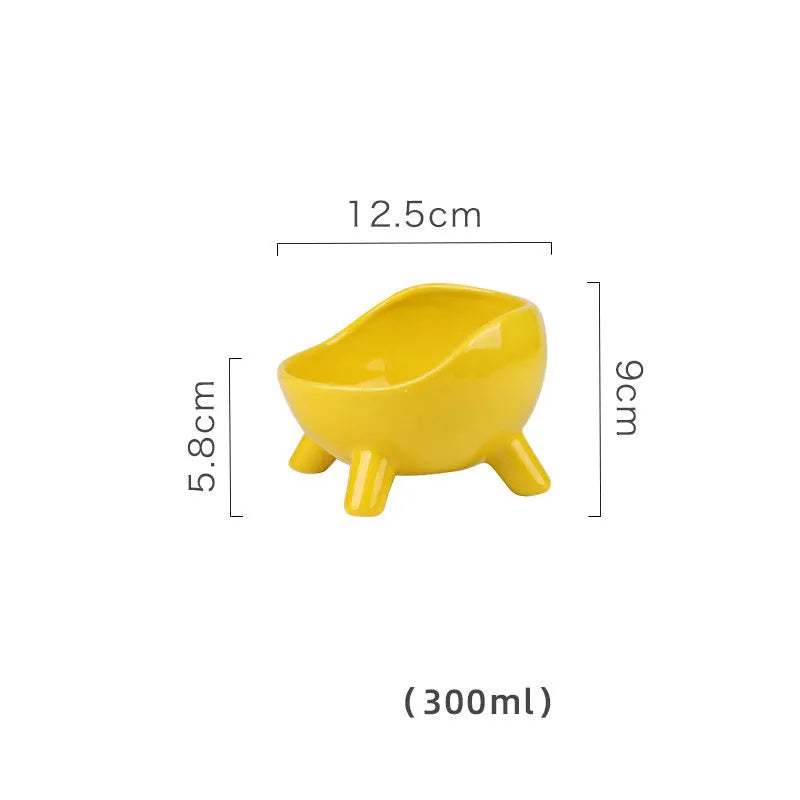 Green ceramic cat food bowl with four-leg stability base on wooden floor
