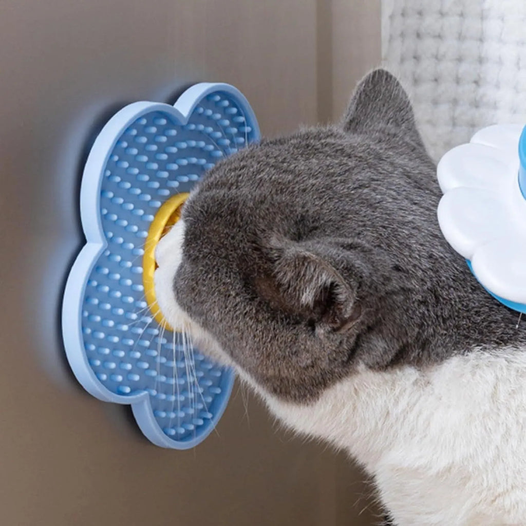 Flower-shaped blue silicone dog licking mat with suction cups on a smooth tile surface.
