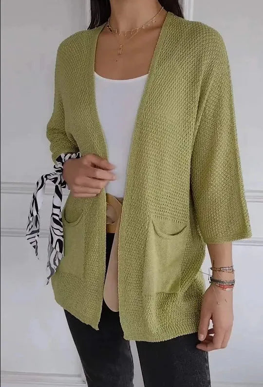 Women's thin waffle weave cardigan coat in army green with pockets, shown on a hanger.