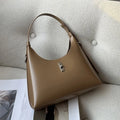 A soft genuine leather dumpling-shaped crossbody shoulder bag in a street style, shown with internal phone pocket.