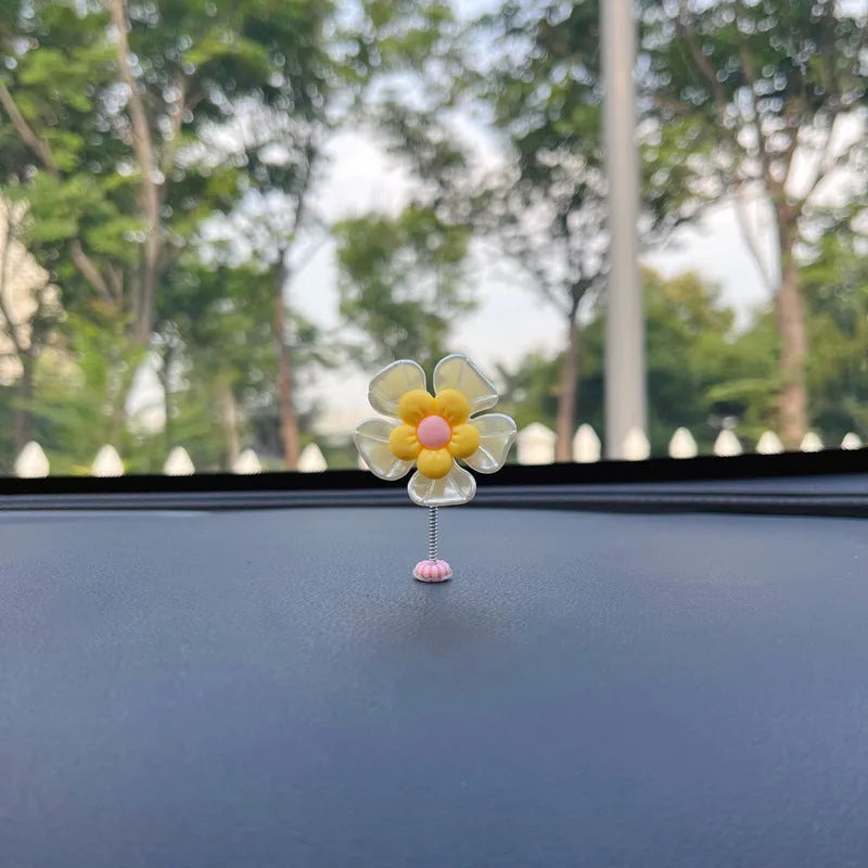 Small colourful plastic car swing decoration hanging from a rear-view mirror.