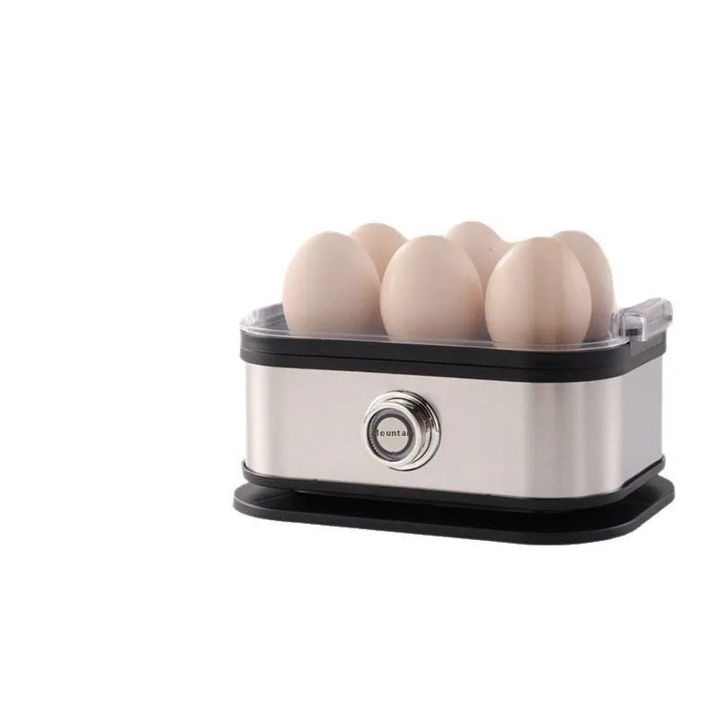 Small black stainless steel portable egg boiler with plug adapters on a countertop.