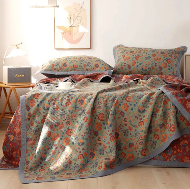 Three-piece cotton gauze bed blanket set with floral botanical pattern, shown with pillowcases.