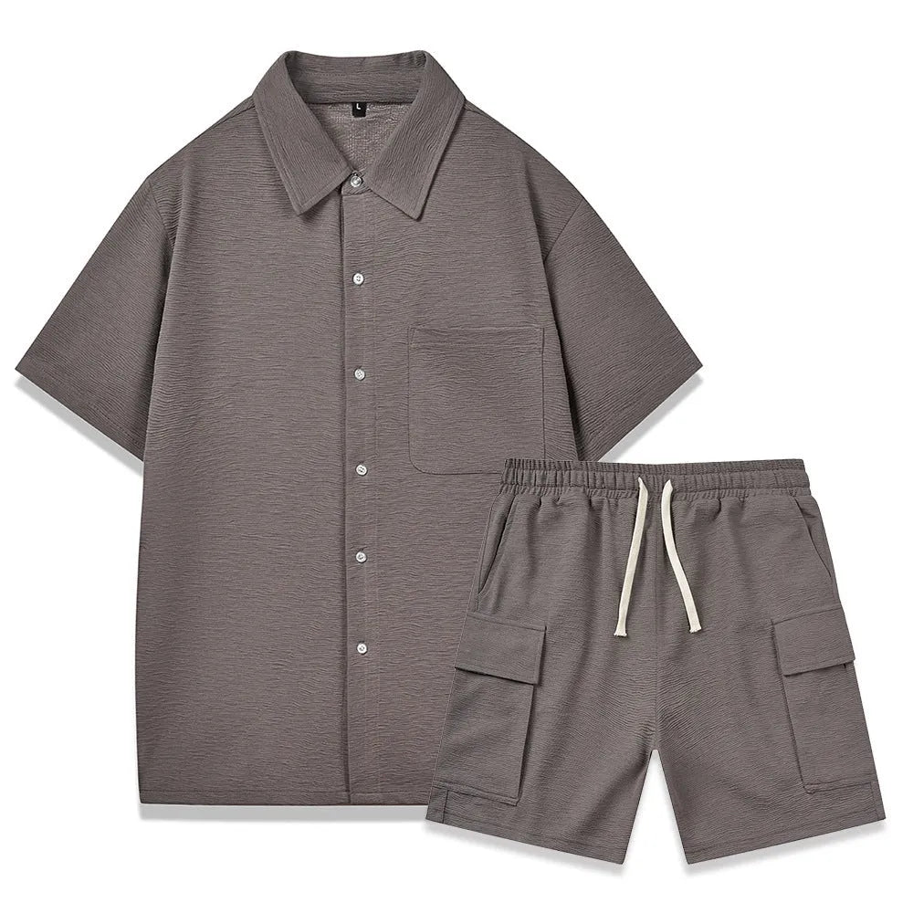 Plain grey polyester two-piece set with short sleeve top and elastic waist shorts laid flat.