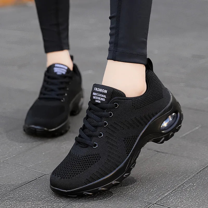 Women's black mesh sneakers with round toe and front lace-up closure showing flat heel design