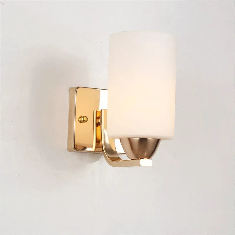 Modern chrome wall lamp with glass lampshade in single head configuration on white wall
