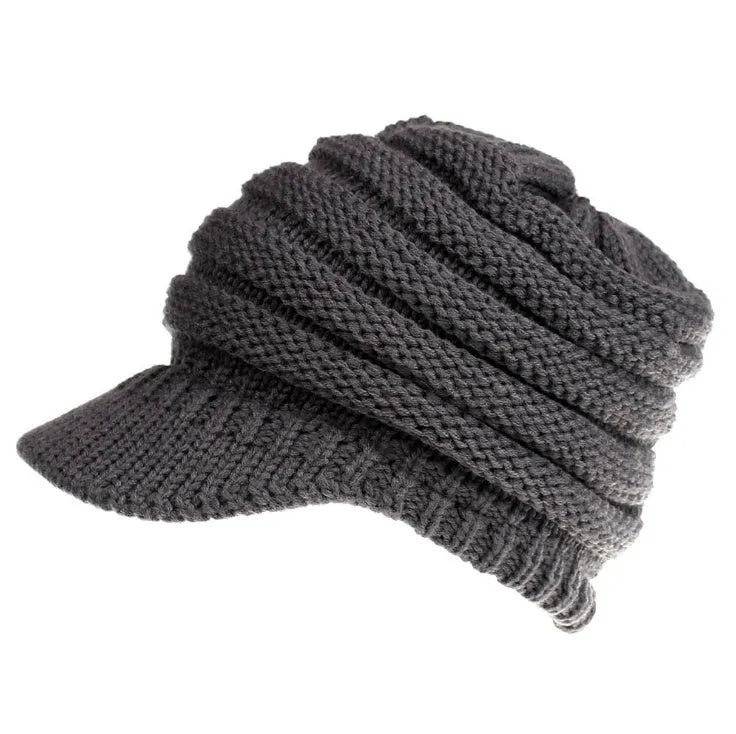 Woman wearing a soft knitted beanie with a ponytail pulled through the hole at the back.