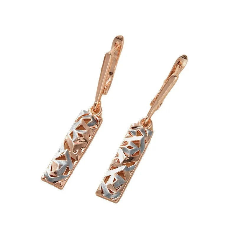 A pair of rectangular hollow stud earrings with a two-tone geometric design on a white background.