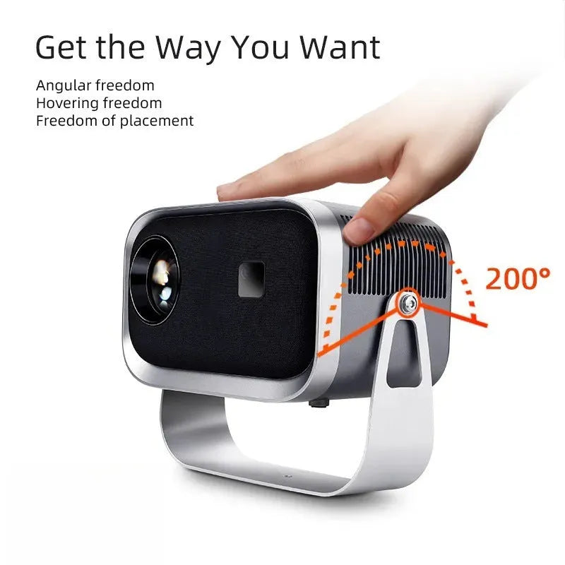 White portable Android smart projector on a table, showing a phone screen mirrored onto a wall displaying a movie scene.
