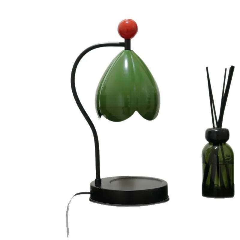 Linglan ancient style melting wax fragrance lamp on a desk, available in cream white or dark green.