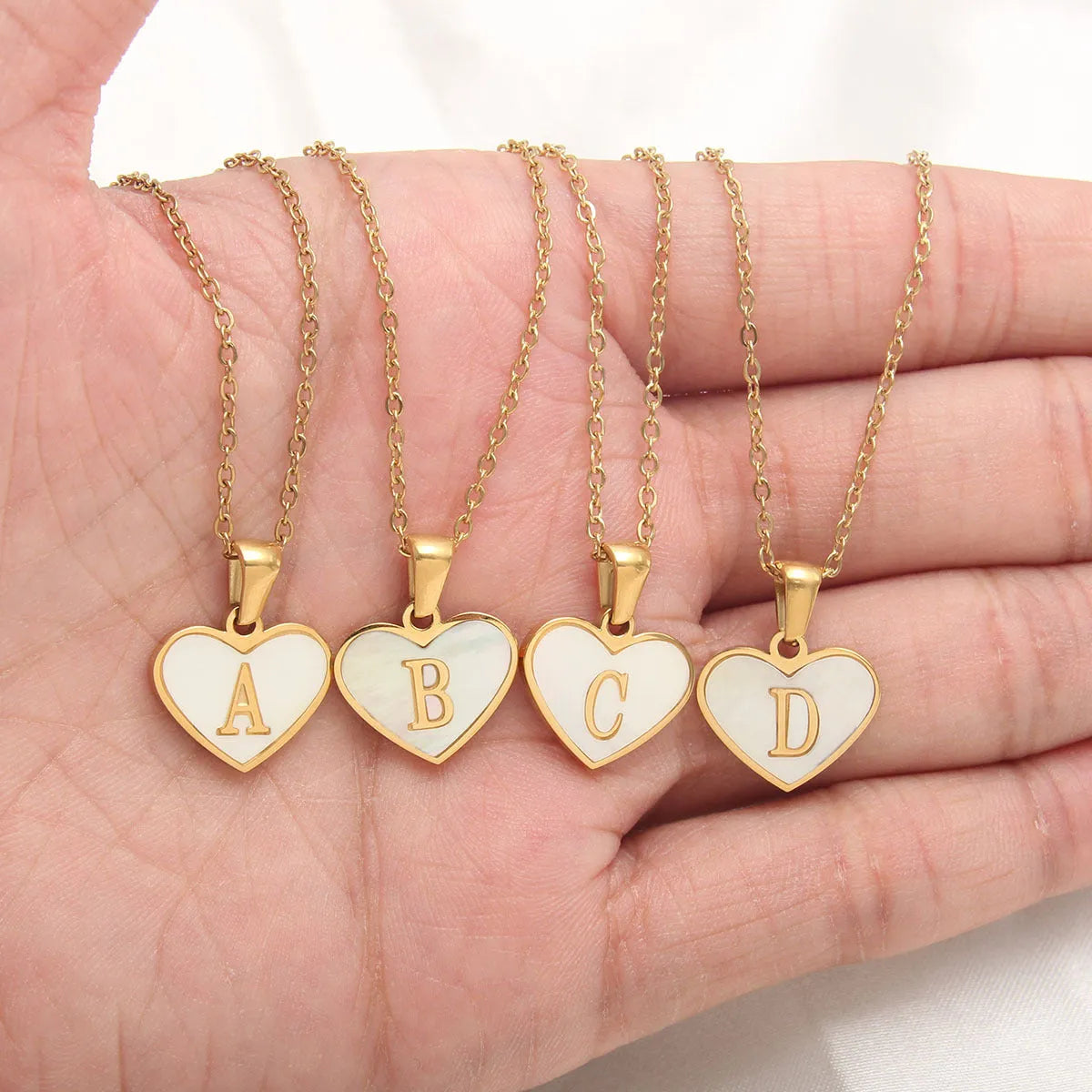 Gold plated heart-shaped personalised necklace with white shell charm on an adjustable chain.