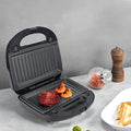 Black electric sandwich pan with double-sided heating, brushed stainless steel cover, and non-stick cooking surface