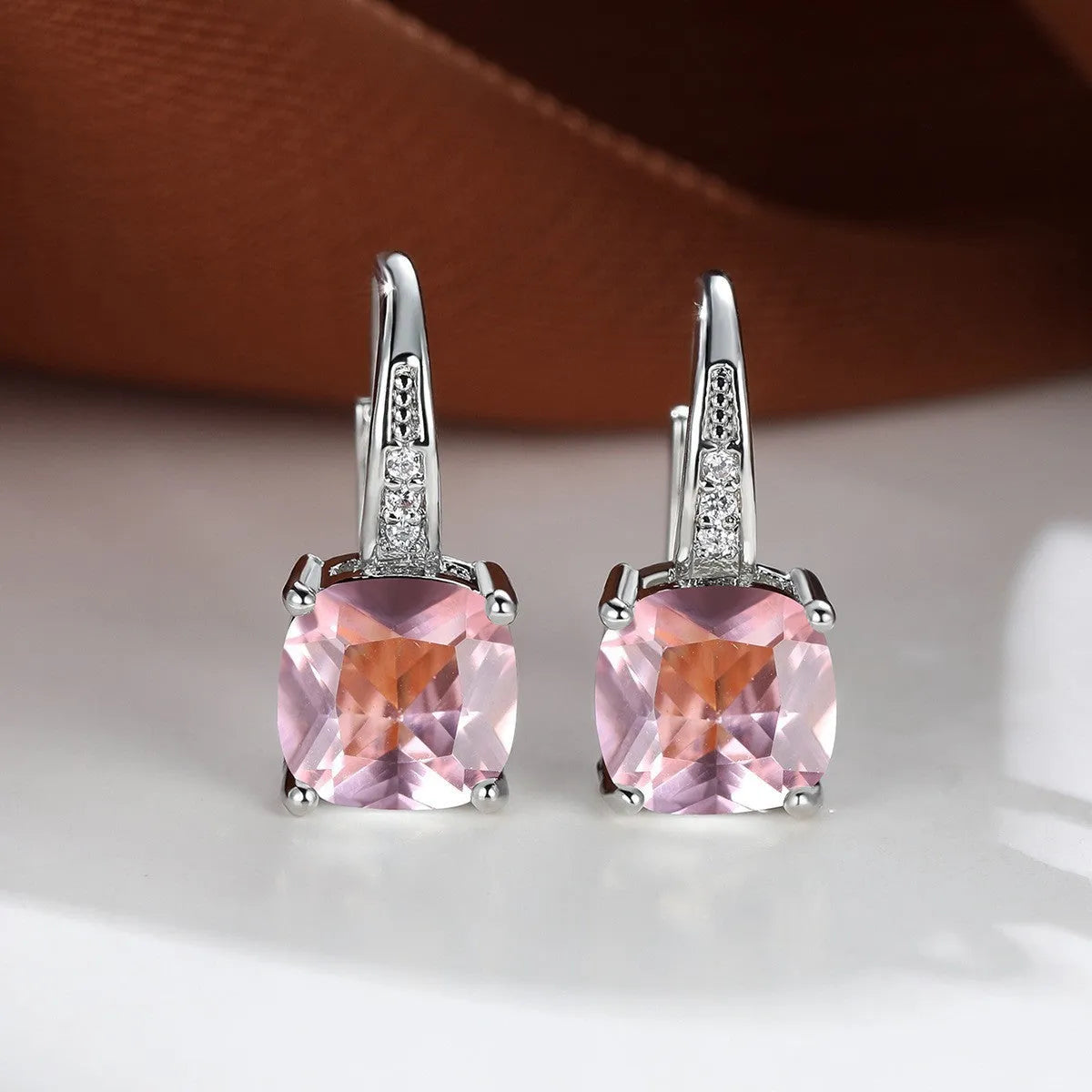 Square geometric ear hook earrings with zircon stones in an electroplated copper setting.