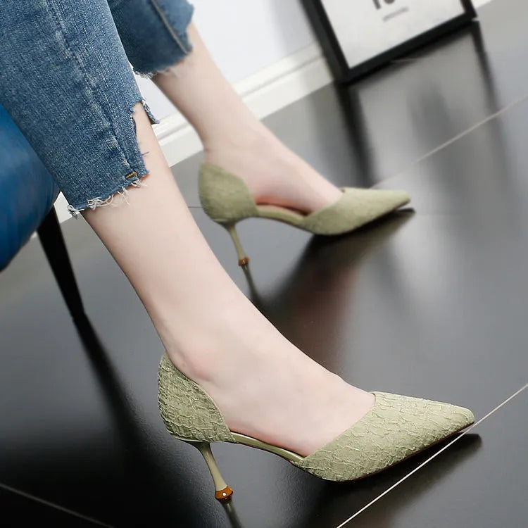 Women's black pointed toe stiletto sandals with a high heel on a plain background.