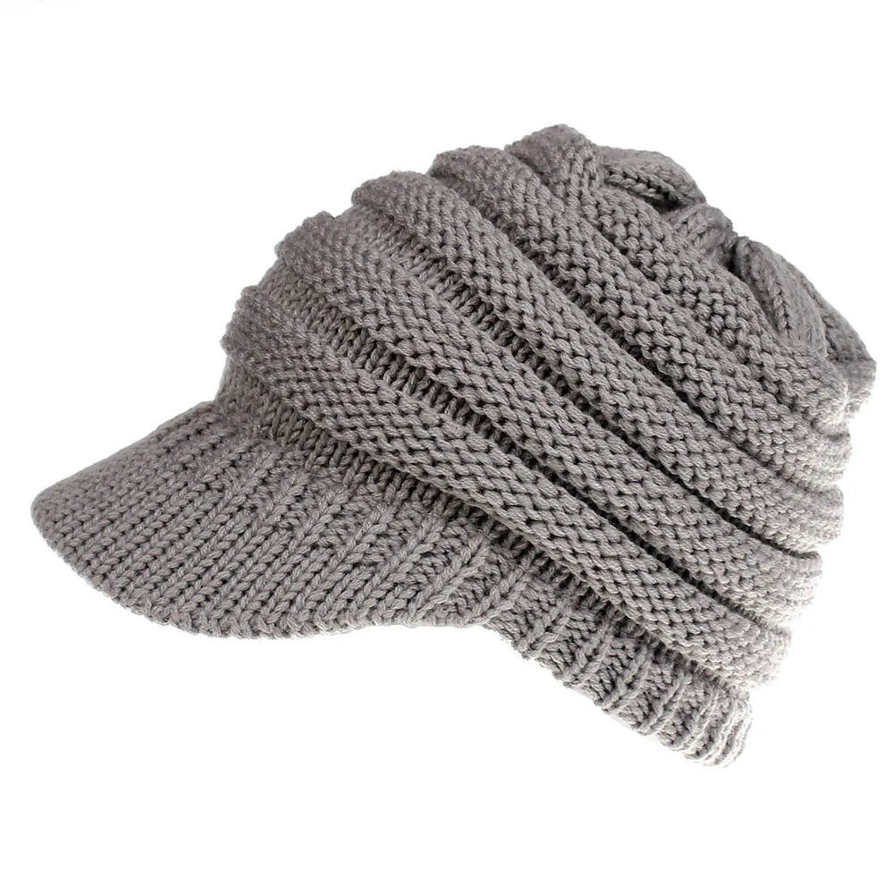 Woman wearing a soft knitted beanie with a ponytail pulled through the hole at the back.