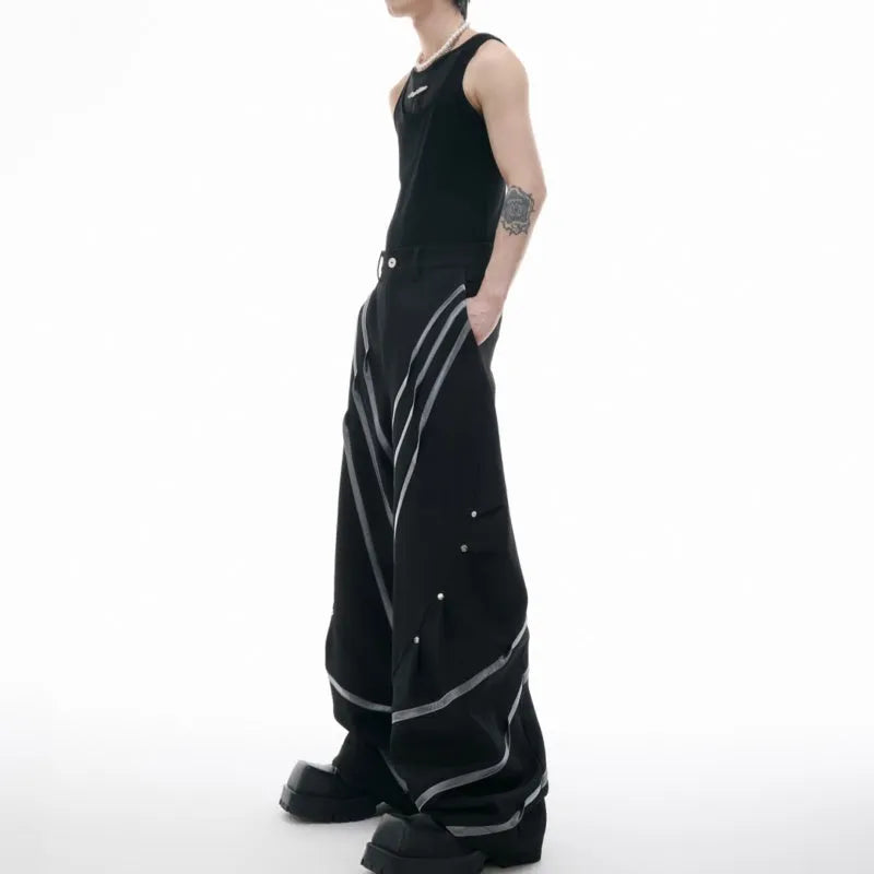 Men's black polyester trousers with front pleats and metal striped rivet details.