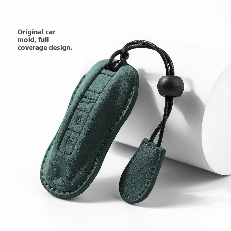 Suede car key cover for Porsche-style fobs in cement grey, dark green, light grey, and orange colour options