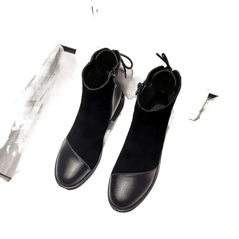 Black women's knee-high Martin boots with a bow detail and side zip on a rubber sole.