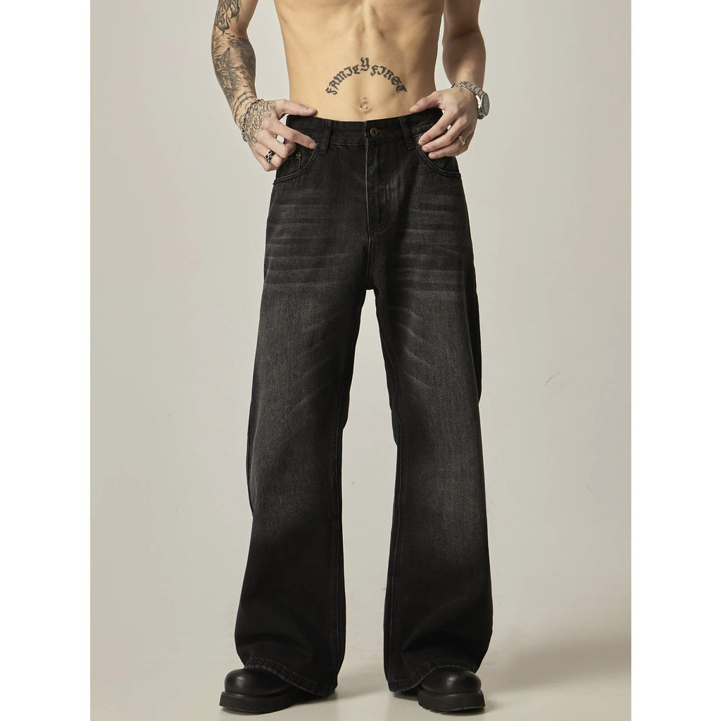 Man wearing black loose-fit straight-leg retro jeans in a casual setting.
