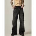 Man wearing black loose-fit straight-leg retro jeans in a casual setting.