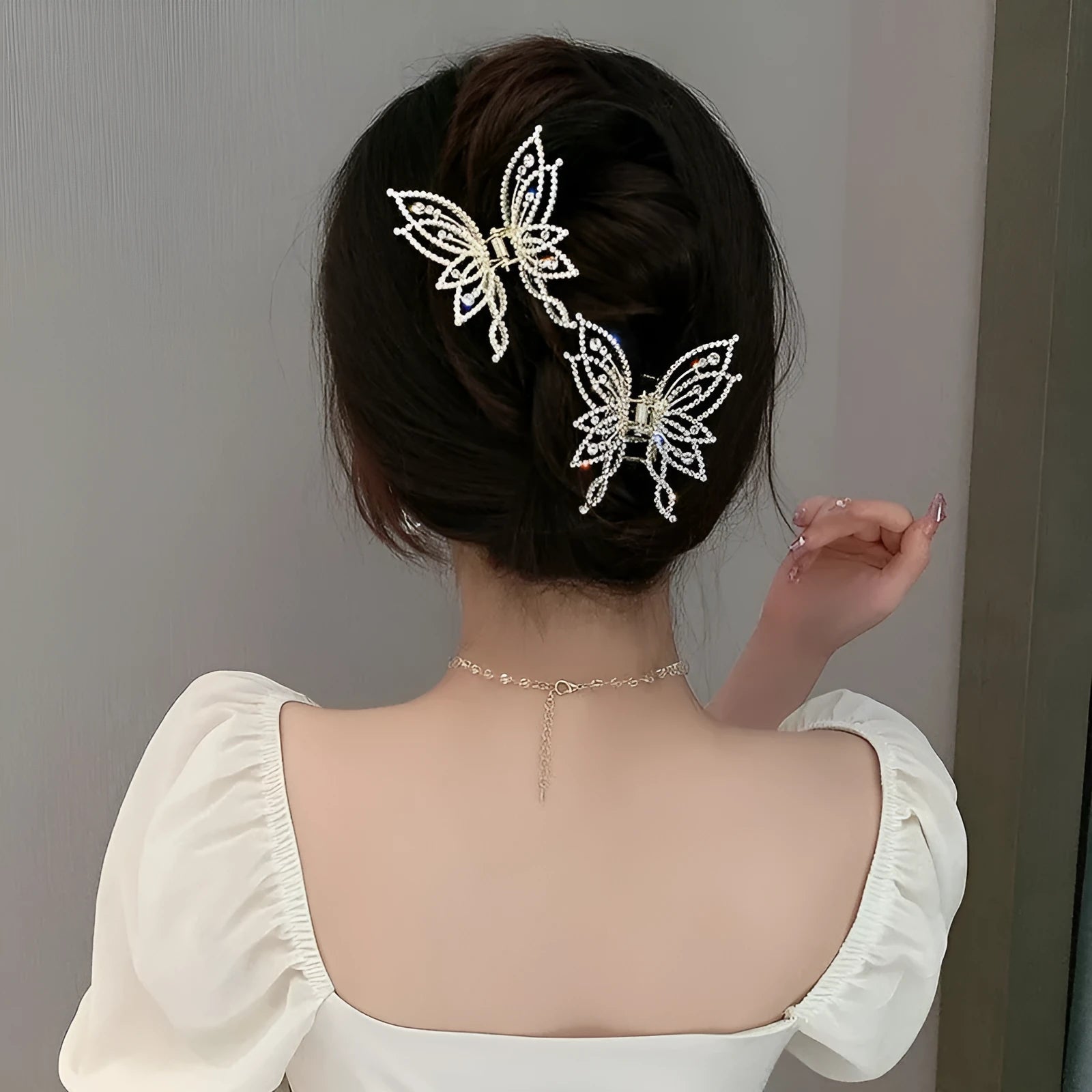 Elegant butterfly-shaped alloy hair clip for women, shown in rhinestone and pearl style options.