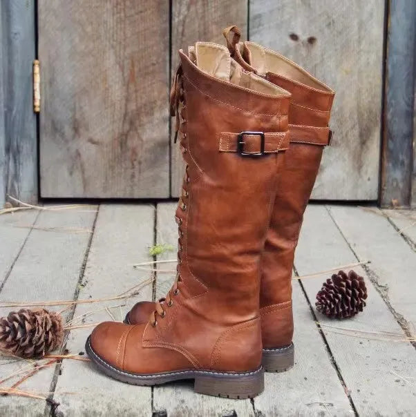 Black chunky heel high leg boots with a round toe and short stout heel on a plain background.