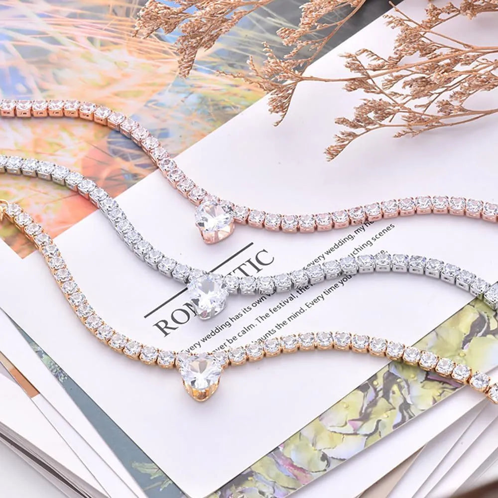 Gold heart-shaped rhinestone pet collar for dogs and cats with adjustable chain on a white background.