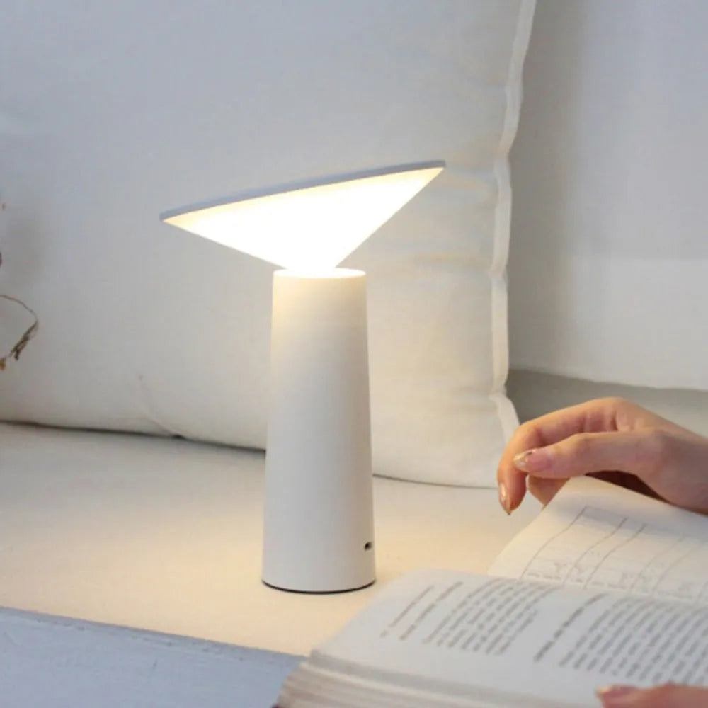 Black USB rechargeable desk lamp with touch sensor and adjustable lamp head on a wooden table.