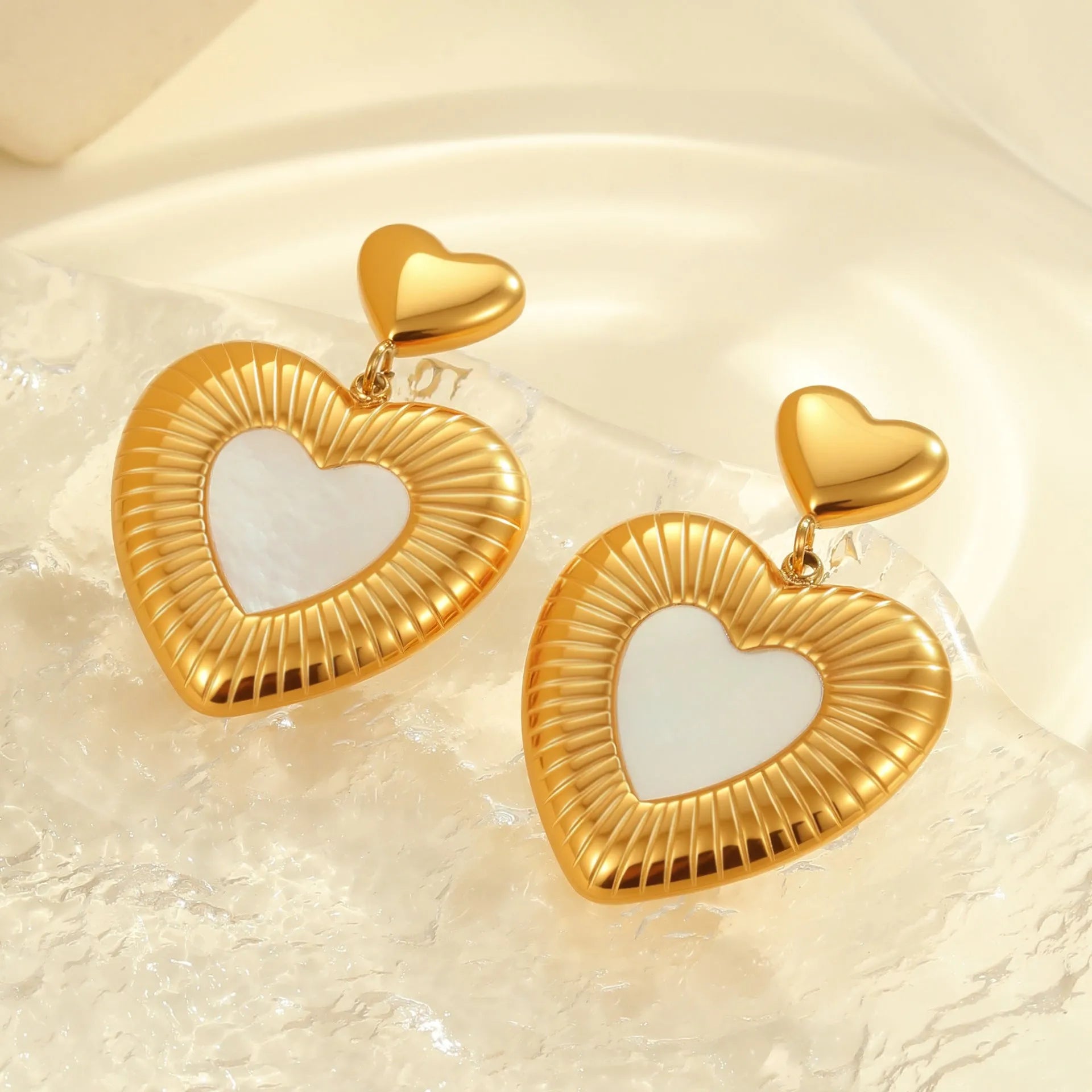 Gold heart-shaped stainless steel stud earrings for women with a love motif.