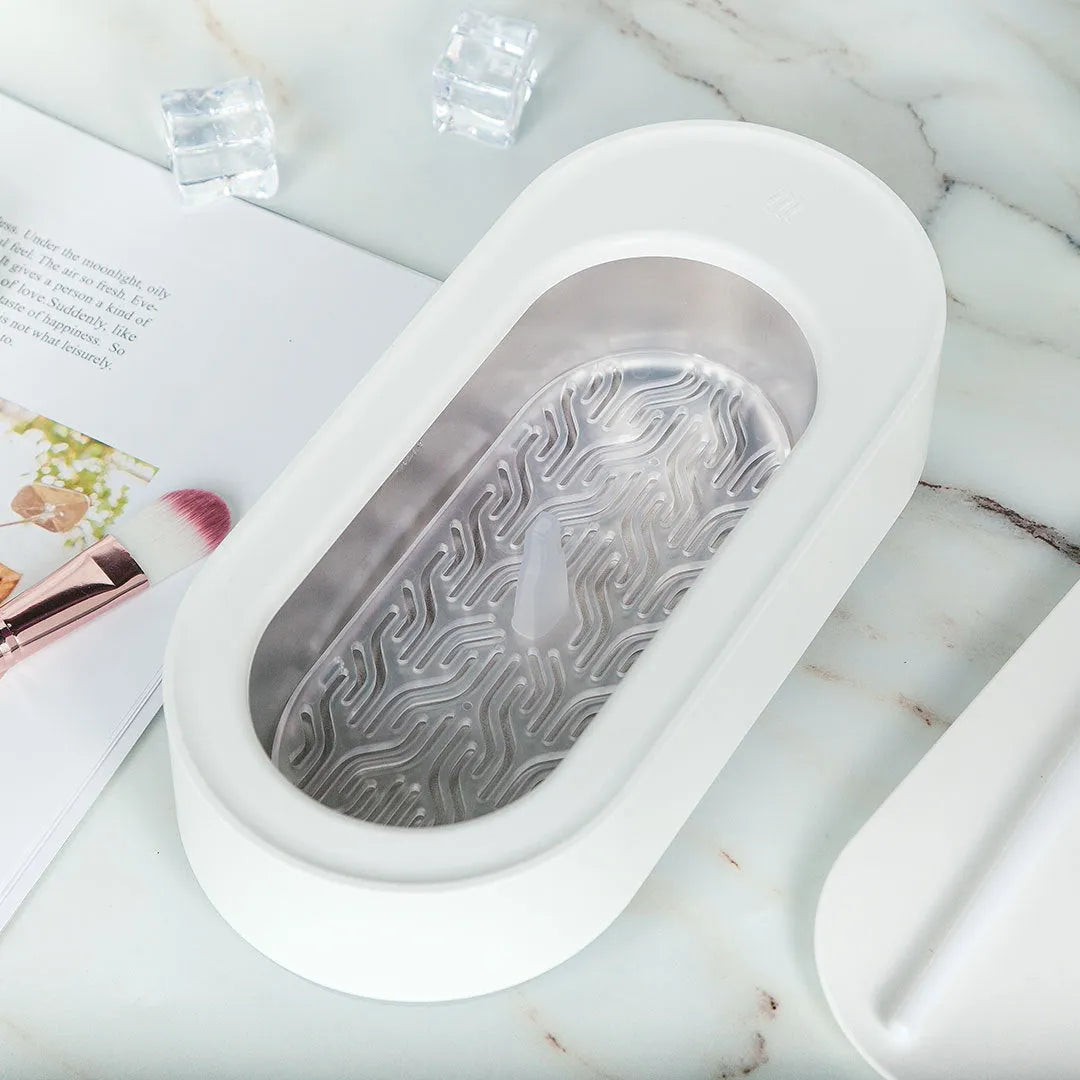 White portable ultrasonic cleaner machine with stainless steel tank for cleaning jewellery and glasses.