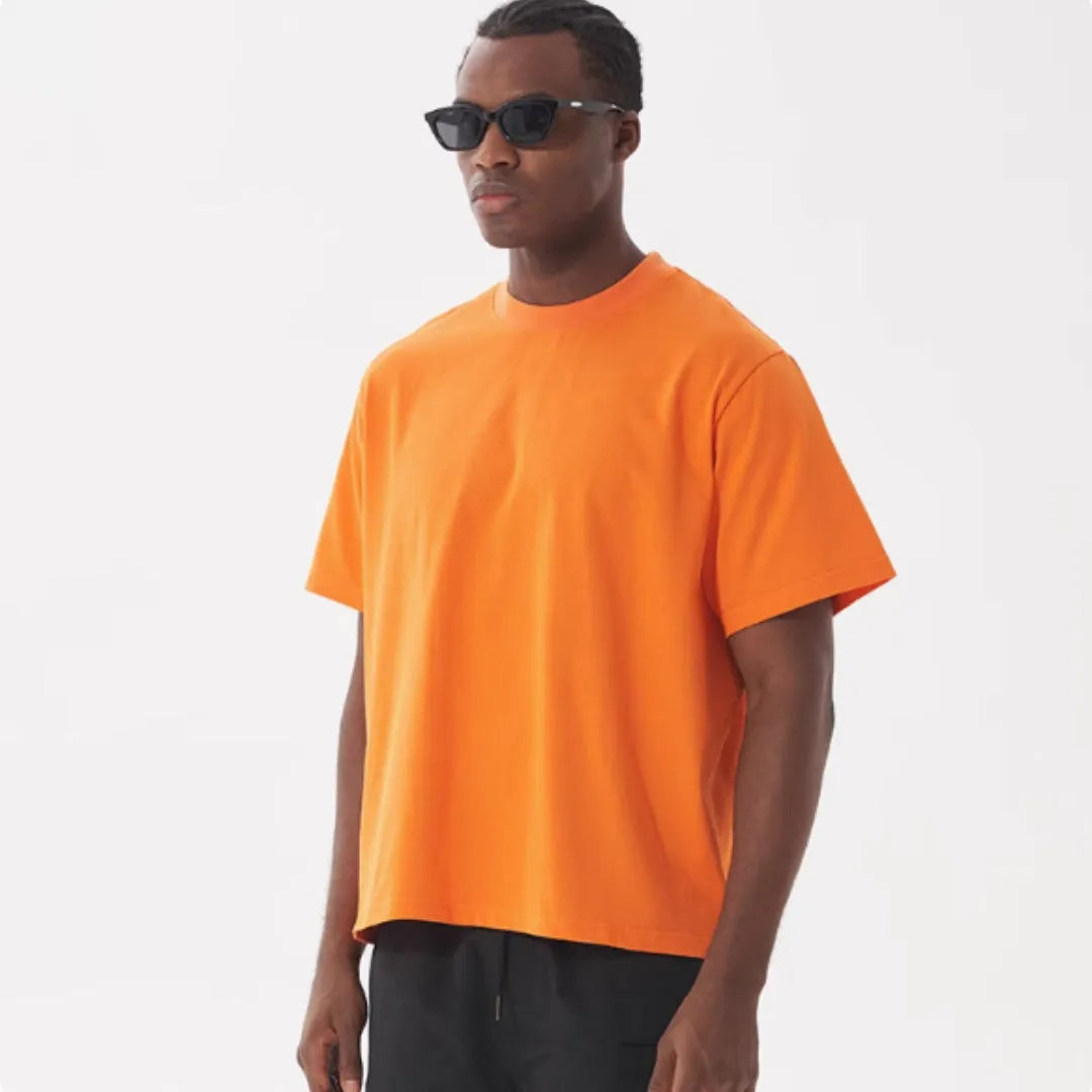 Man wearing a loose fit apricot coloured pure cotton t-shirt, short sleeves, casual American style.