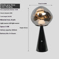 Volcanic lava mini table lamp with metal holder in gold finish, USB magnetic charging, on a bedside table