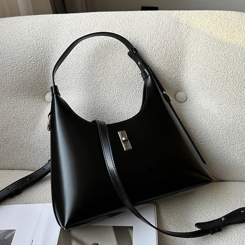 A soft genuine leather dumpling-shaped crossbody shoulder bag in a street style, shown with internal phone pocket.