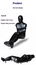 Black patent leather bondage kit showing body wrap garment and six ratchet tie-down straps