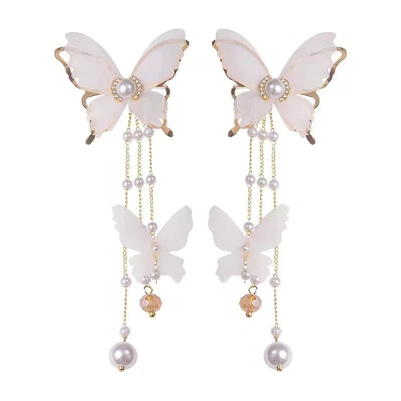 White butterfly-shaped women's earrings with dangling tassels, lace detail, pearl accents, and rhinestone sparkle.