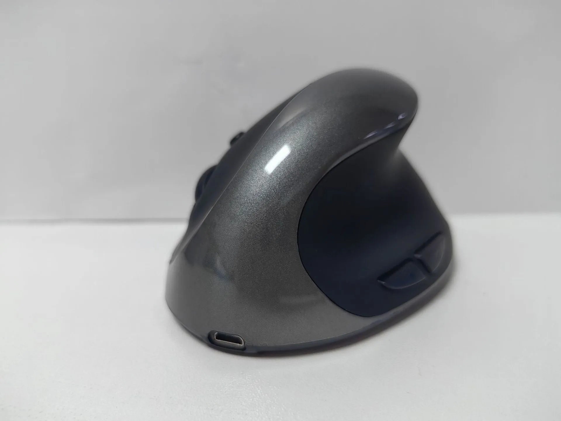 Three Generations wireless vertical ergonomic mouse in black, shown next to a laptop.