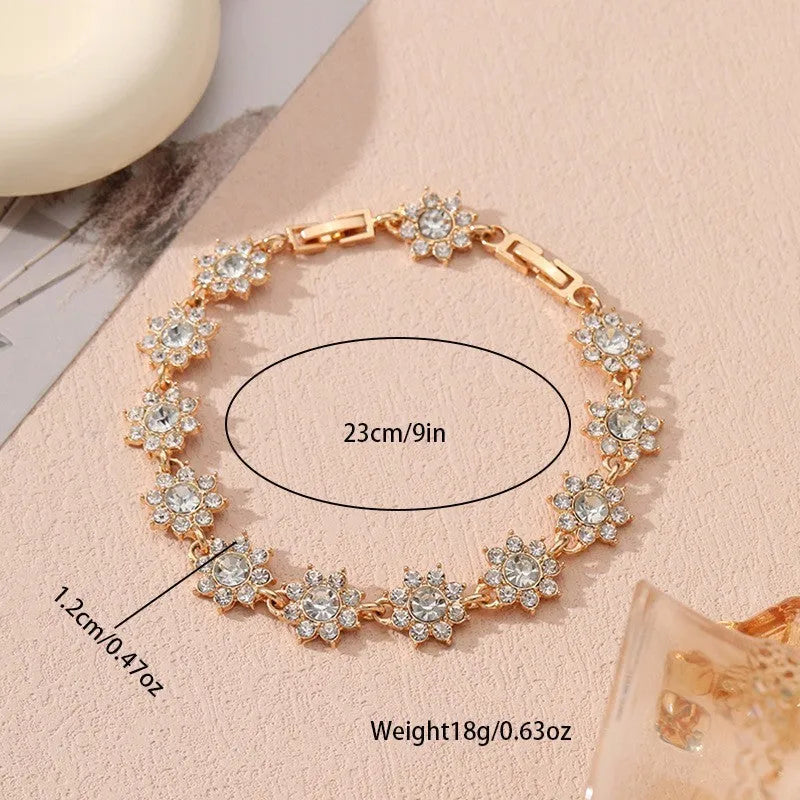 A gold or silver electroplated zinc alloy flower bracelet with coloured gems.